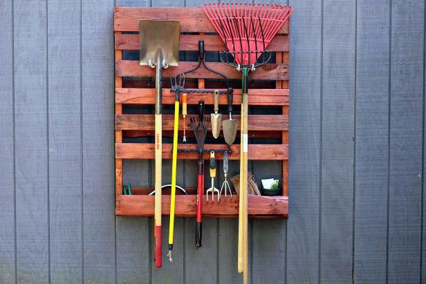 Turn a wooden pallet into a garden tool rack and preserve outdoor space with vertical storage