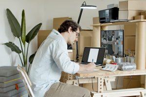 Man with glasses carefully writing down and follows pro packing guide to keep your storage unit clutter-free.