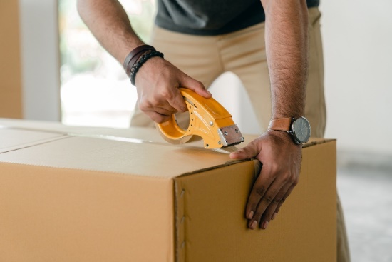 A man duct-taping a box