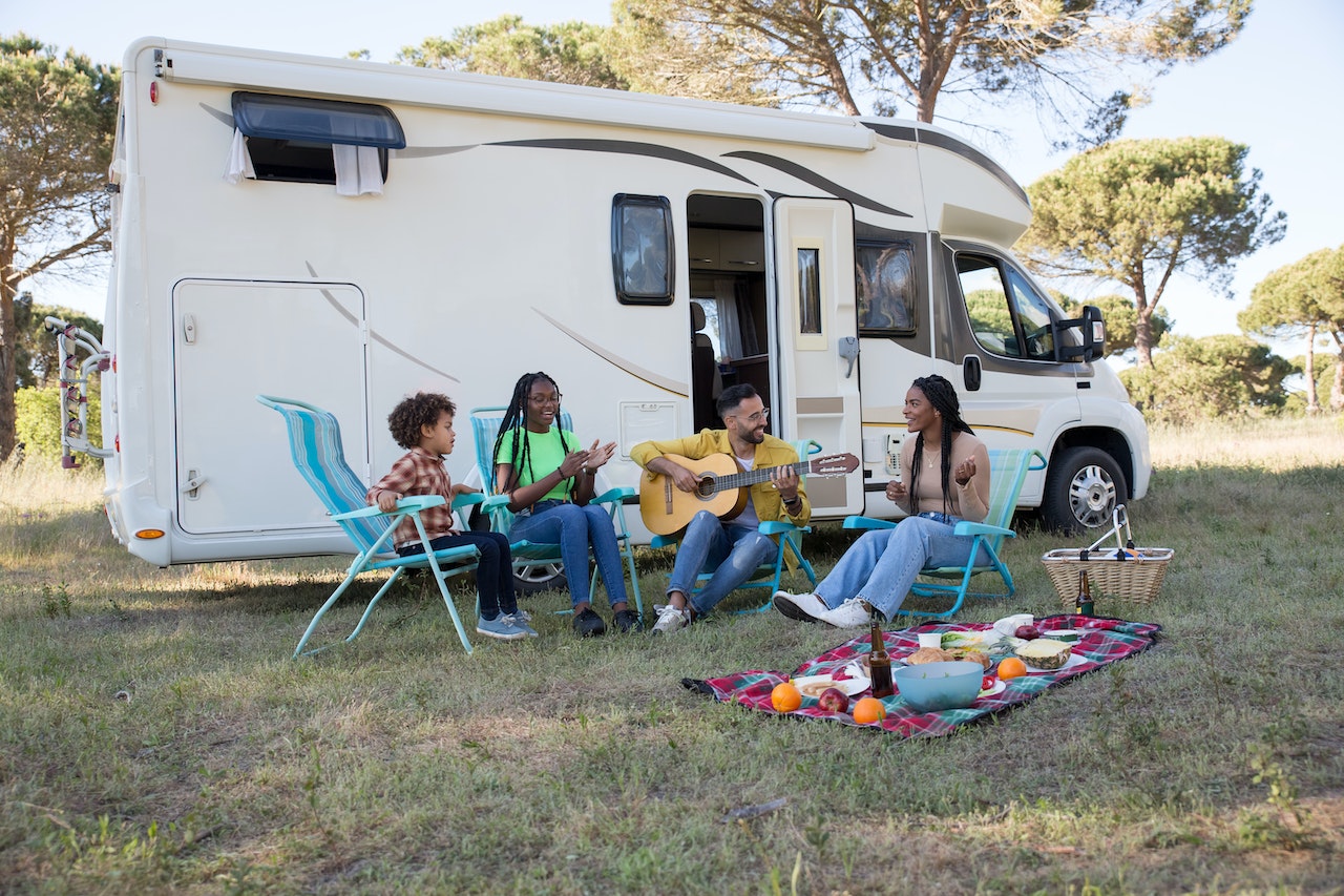 A group of people sitting in chairs outside of a rv

Description automatically generated with low confidence