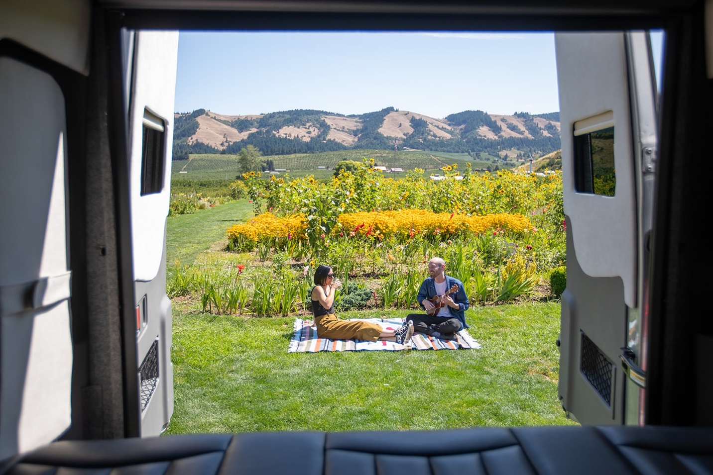 A person and person sitting on a blanket in a field

Description automatically generated with low confidence