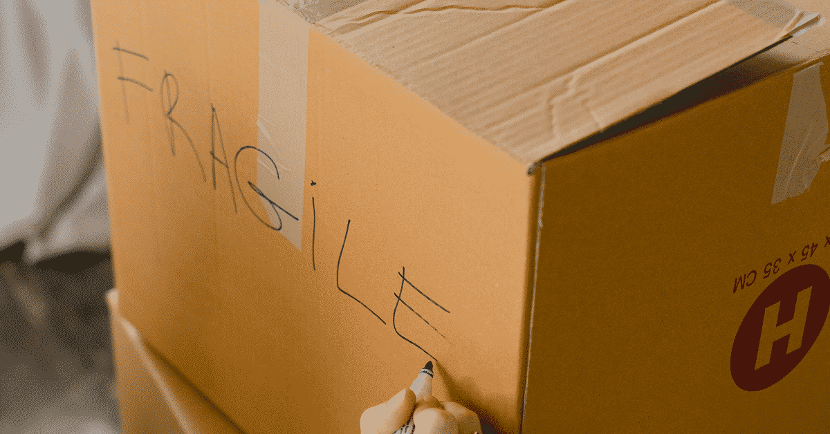 A hand writing on a cardboard box

Description automatically generated