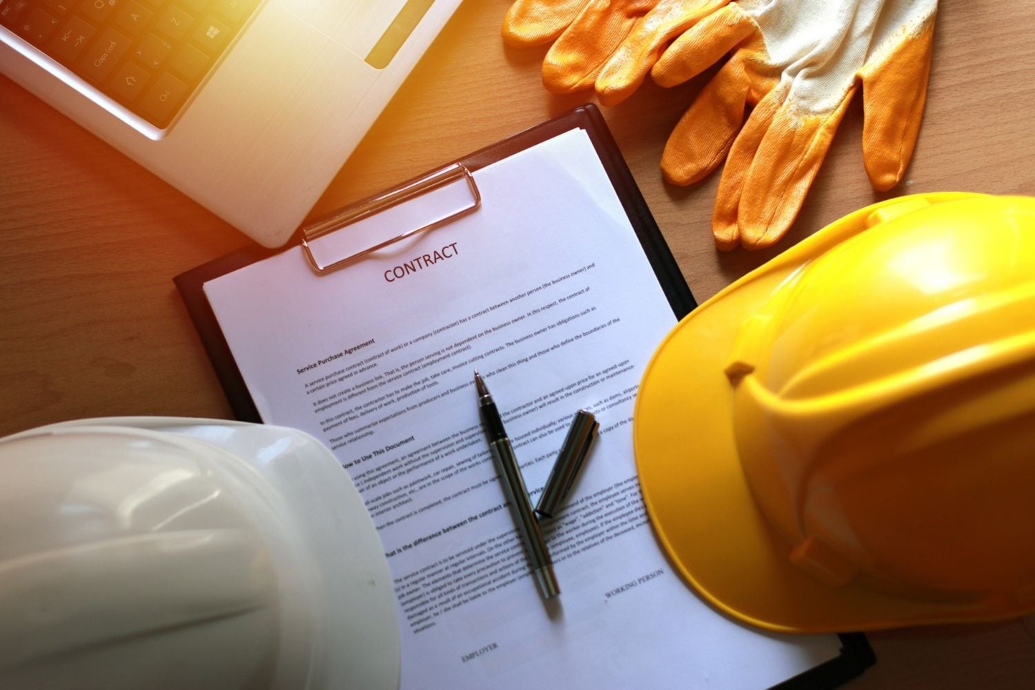 A pen and a clipboard with a helmet and gloves