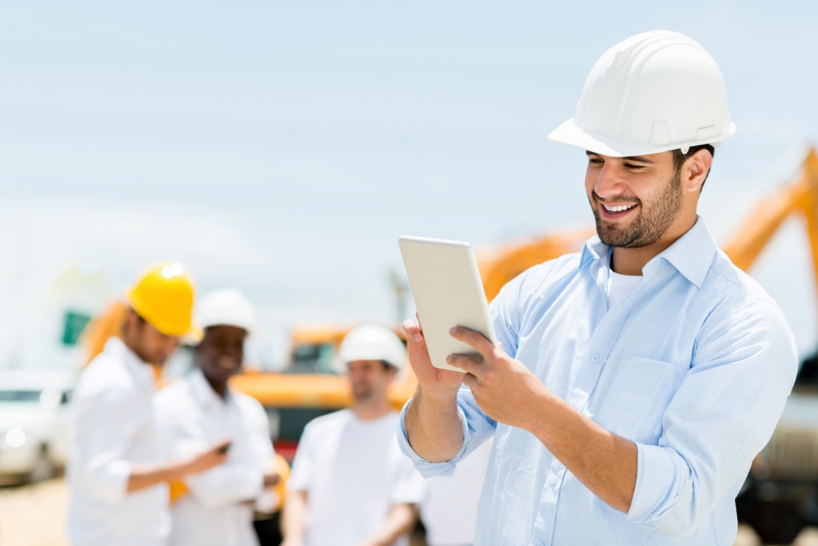 A person wearing hardhats and holding a tablet