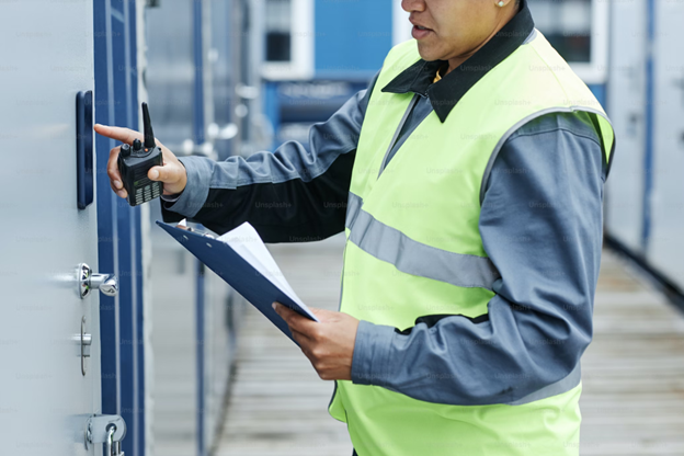A person in a safety vest holding a clipboard and a clipboard

Description automatically generated