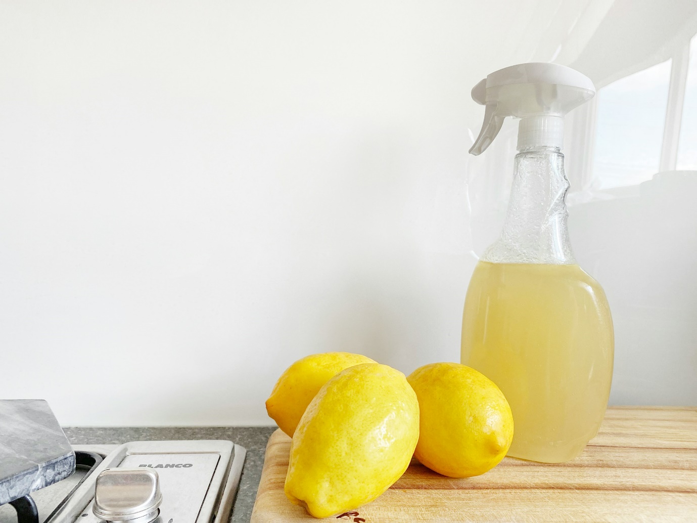 Lemons next to a spray bottle and lemons