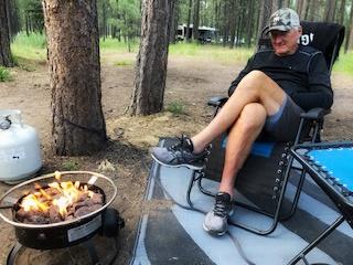 Tom Seibolt sits by fire on RV camping trip